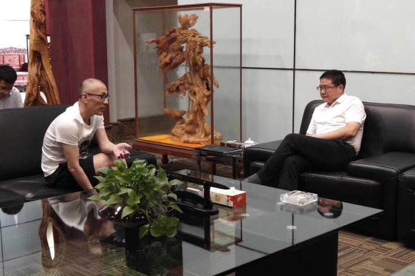 大冶市市长王刚（右）与中亚电子城集团总裁黄炳煌（左）进行交流