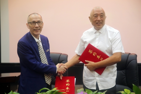 黄总裁（左）与中国延安精神研究会发展组组长马晓文（右）签订战略协议