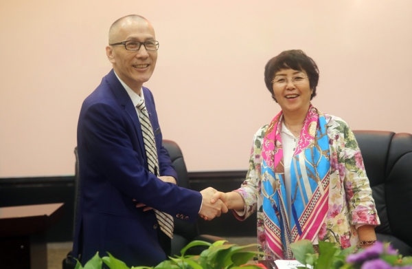 黄总裁（左）与中国延安精神研究会副秘书长张姐莉（右）签订战略协议