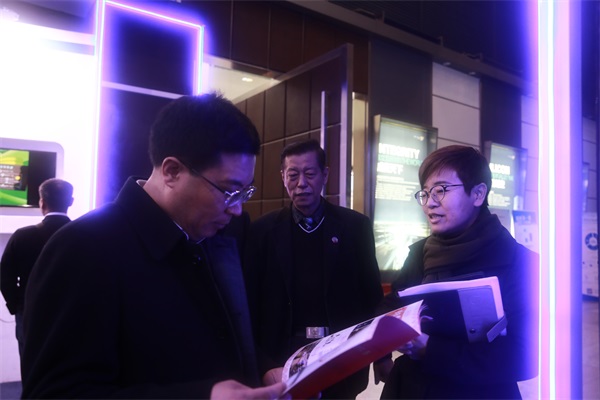 王宝雨区长认真翻阅中亚数字创意中心VR+智慧党建宣传册