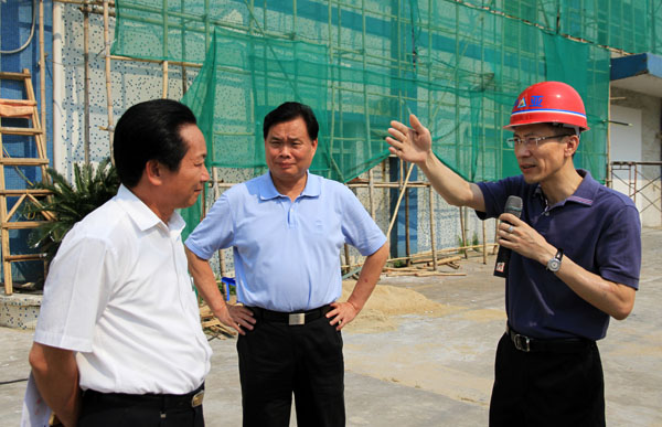 李文龙区长（中）、龙耀庭副区长（左）听取黄炳煌总裁关于项目规划的介绍